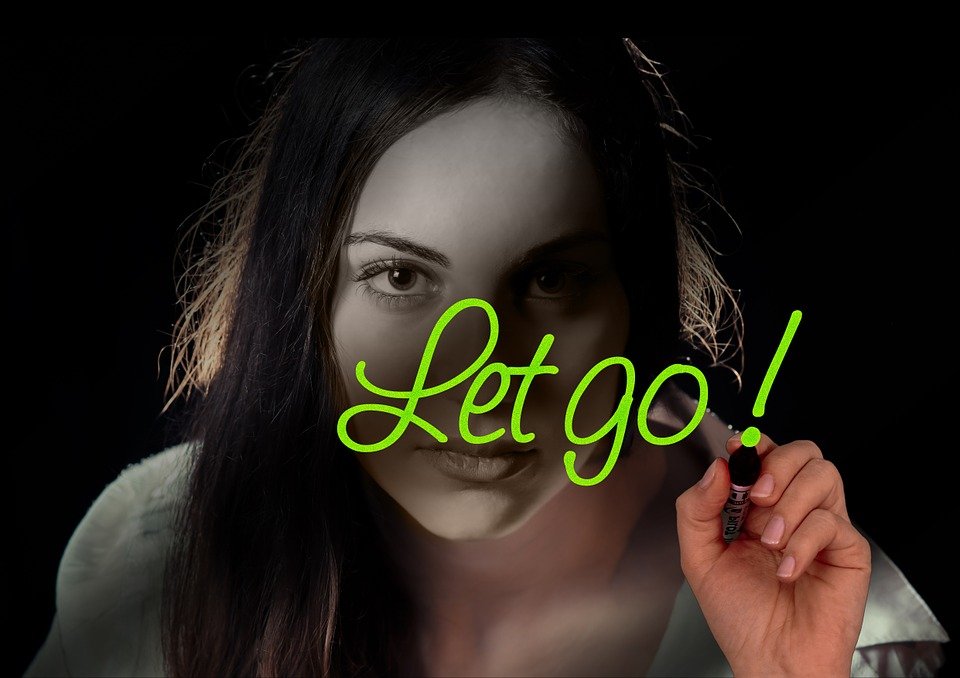 Featured photo for Why can't I let go? Girl with a green marker with the words Let Go